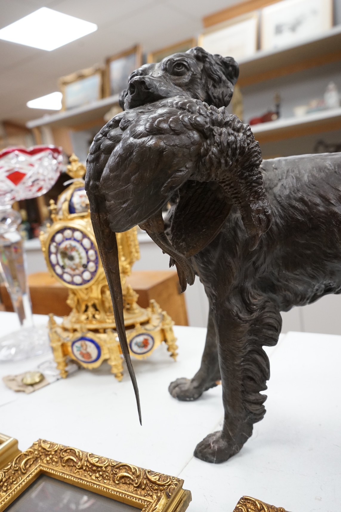 A large bronzed metal study of a retriever and pheasant, 56cm wide